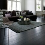 black wood flooring black wooden flooring with brown sofa and round table living room HSGZDWJ