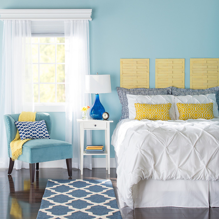 runner rugs beside bed bedroom with blue walls. MBGVJTL