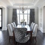 Gray dining room features a tray ceiling accented with a satin
